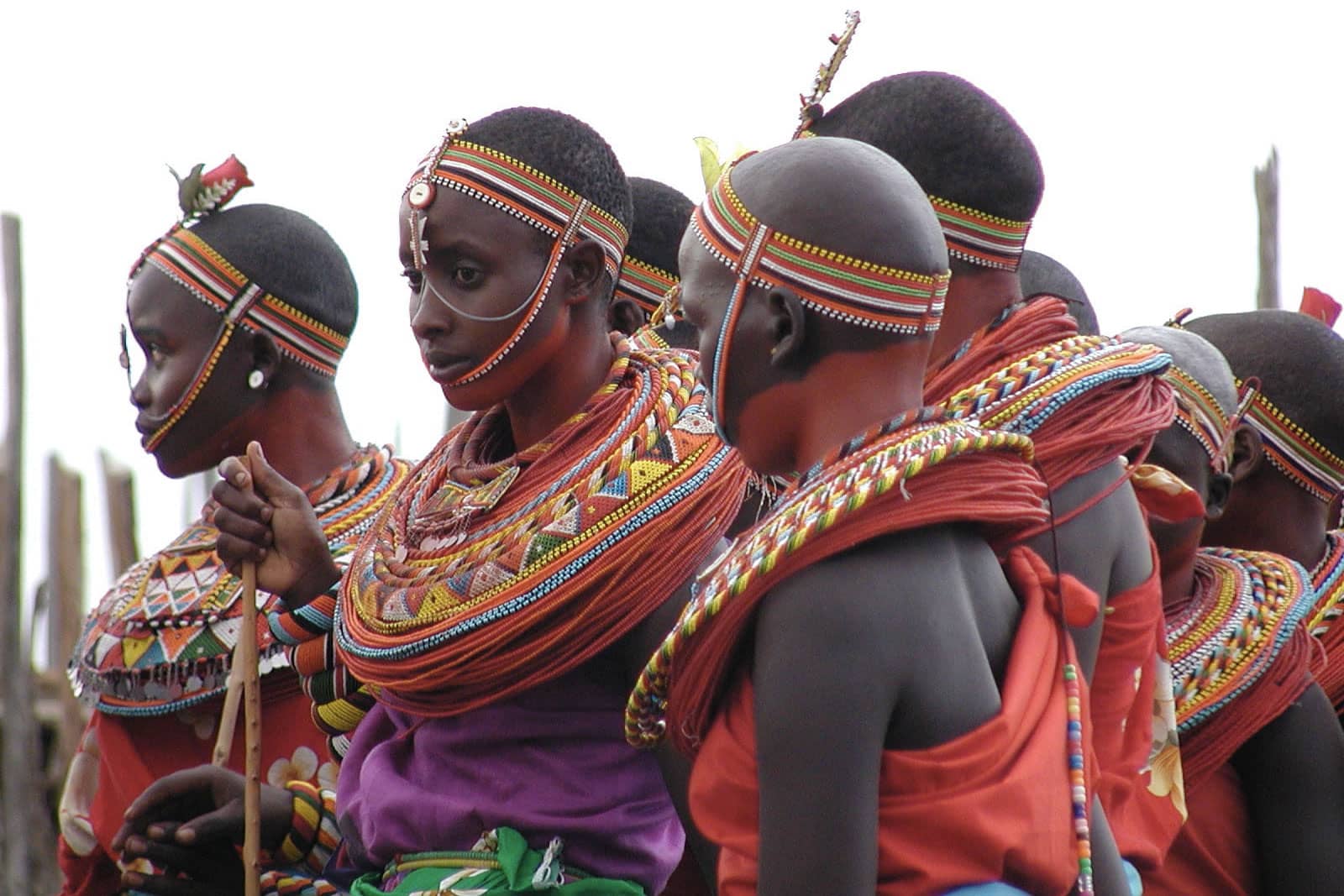 Samburu people dressed in traditional clothing including red, white, green and black headdresses and beaded collars